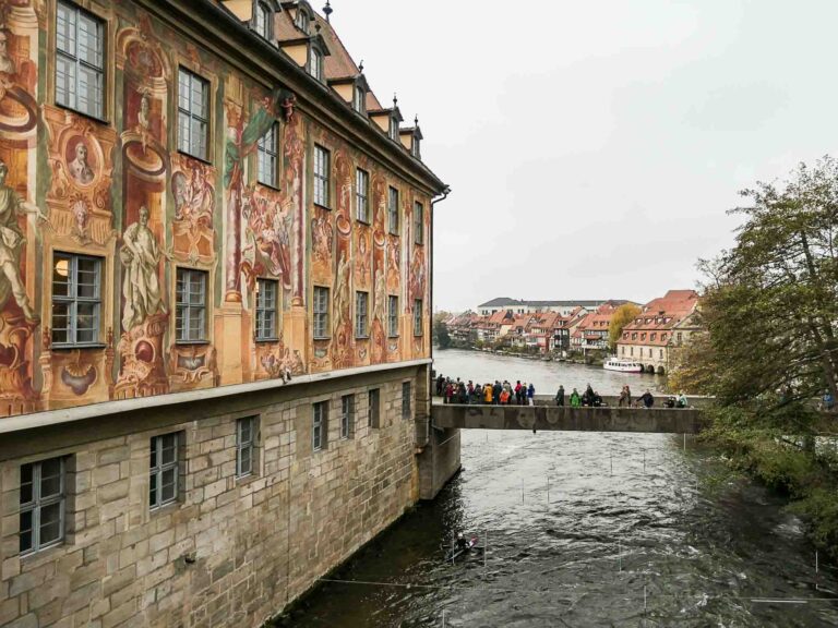 Bunt bemalte Häuserfassade neben Fluss und Brücke Foto: Lisa Freudlsperger