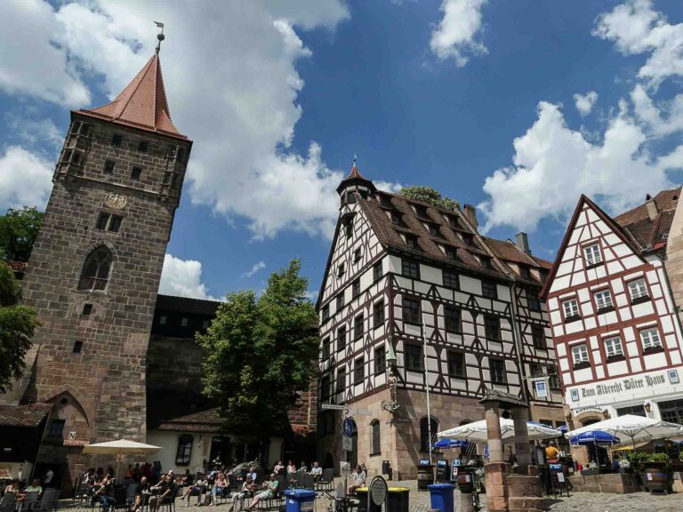 Zwei große Fachwerkhäuser und ein steinerner Turm rahmen den Platz ein. Foto: Lisa Freudlsperger