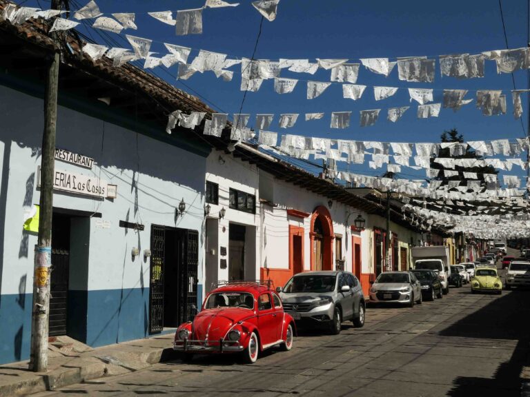 Bunte Häuser und roter VW Käfer in den Straßen von San Cristobál de las Casas.