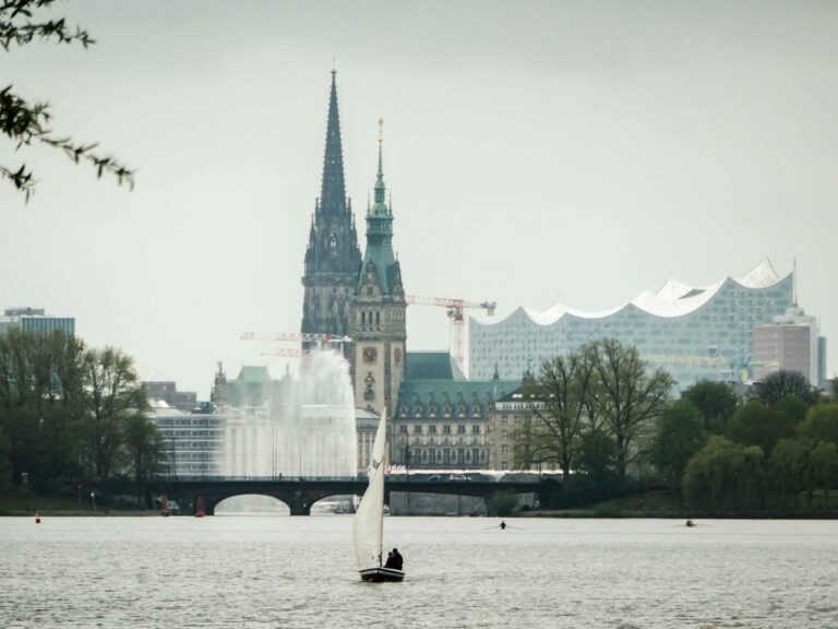 Blick über die Alster auf Segler und ikonische Gebäude von Hamburg Foto: Lisa Freudlsperger
