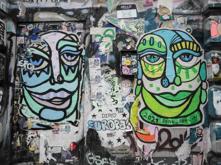 Street Art: Zwei bunte Gesichter kleben an einer Wand Foto: Lisa Freudlsperger