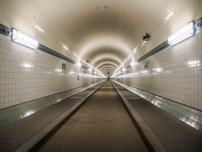 Blick in den Elbtunnel mit weiß gefliesten Wänden und künstlichem Licht. Foto: Lisa Freudlsperger