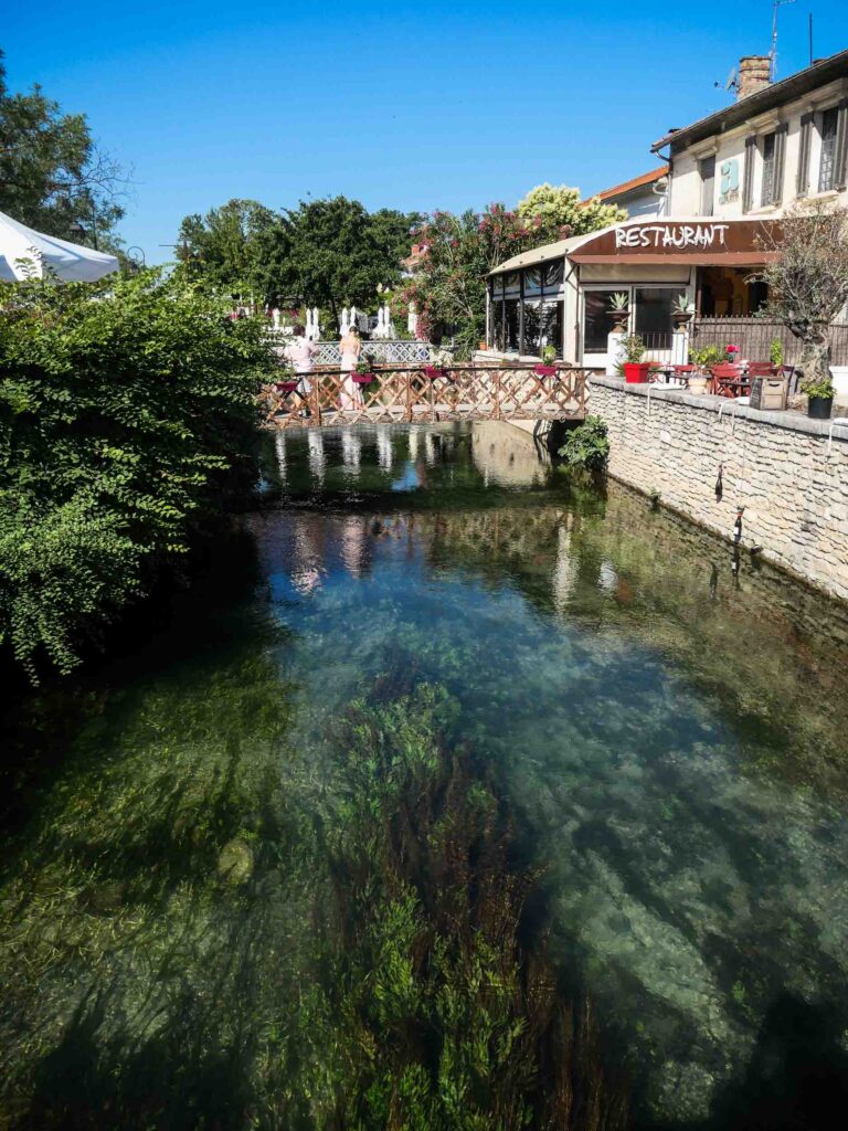 Häuser und Restaurant direkt am Fluss in grün blauer Farbe. Foto: Lisa Freudlsperger