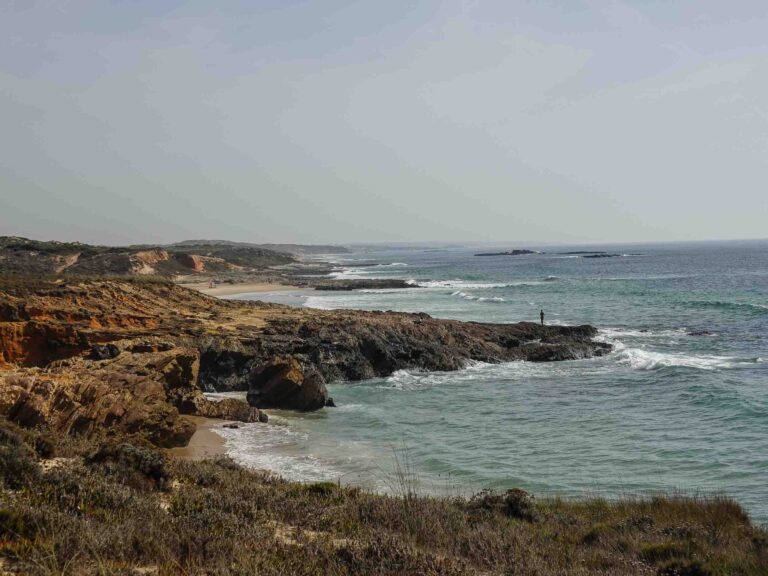 Blick auf felsigen Strandabschnitt und Fischer in der Ferne. Foto: Lisa Freudlsperger