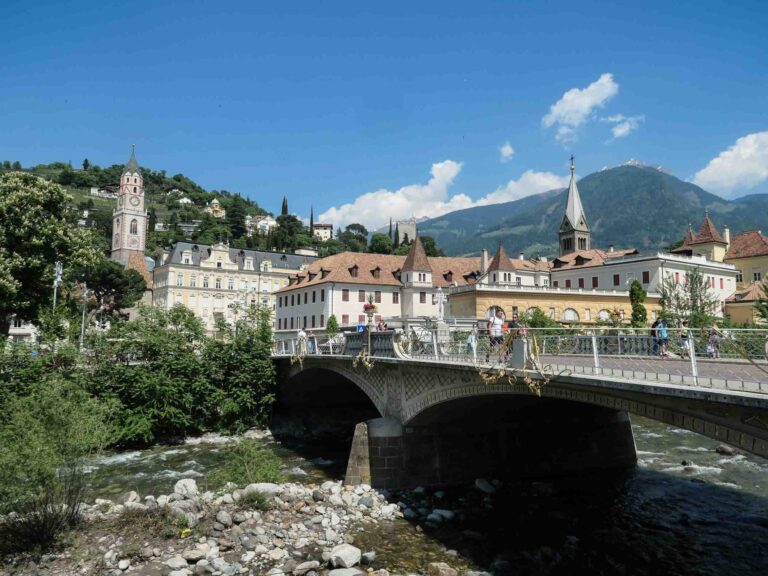 Blick auf Brücke, Fluss und zwei Kirchtürme mit Bergen im Hintergrund Foto: Lisa Freudlsperger