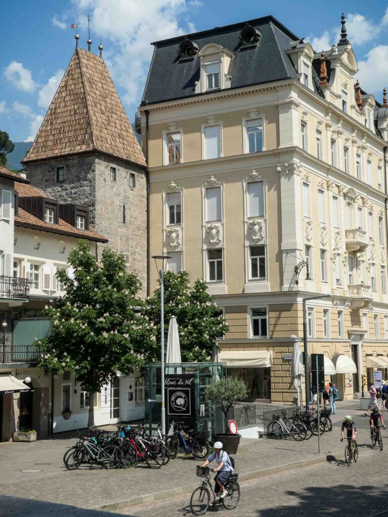 Mehrstöckiges Haus, altes Stadttor und Radfahrer im Vordergrund Foto: Lisa Freudlsperger