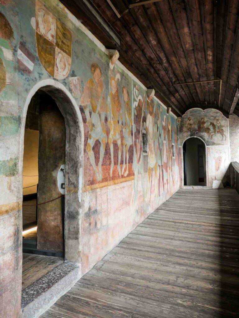 Wände voller Fresken und zwei Türen sowie ein Weg aus Holz in der Burganlage Foto: Lisa Freudlsperger